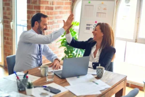 Man and woman sharing a corporate high-five, celebrating success.