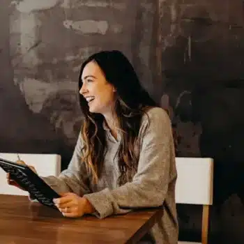 Satisfied client sitting with a notebook, looking organised and content.
